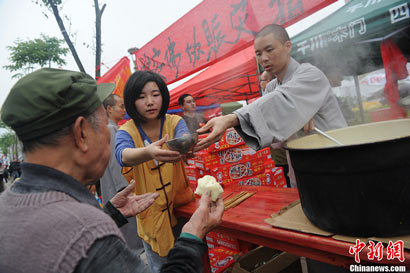 僧人在地震灾区向民众发放免费热粥