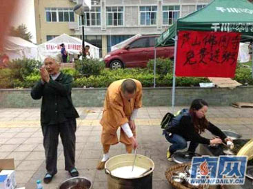 僧人在地震灾区向民众发放免费热粥
