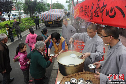僧人在地震灾区向民众发放免费热粥