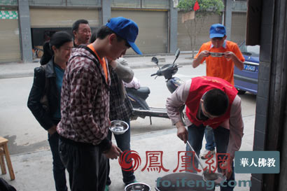 僧人在地震灾区向民众发放免费热粥